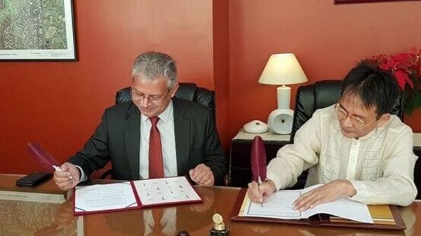 Mr. Ravi Sharma (left) and Mr. Huan Wei (right) sign the memorandum