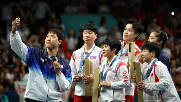 Paris 2024 Olympics - Table Tennis - Mixed Doubles Victory Ceremony - South Paris Arena 4, Paris, France - July 30, 2024. Bronze medallist Jonghoon Lim of South Korea takes selfie with Yubin Shin of South Korea and gold medallists Chuqin Wang of China and Yingsha Sun of China with silver medallists Jong Sik Ri of North Korea and Kum Yong Kim of North Korea on the podium with their medals after winning. REUTERS/Kim Hong-Ji     TPX IMAGES OF THE DAY