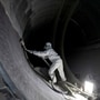 A worker prepares a blade of a power-generating windmill turbine at the plant of Adani Green Energy in Mundra. (Reuters)