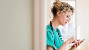 A nurse checking on their schedule in a digital tablet