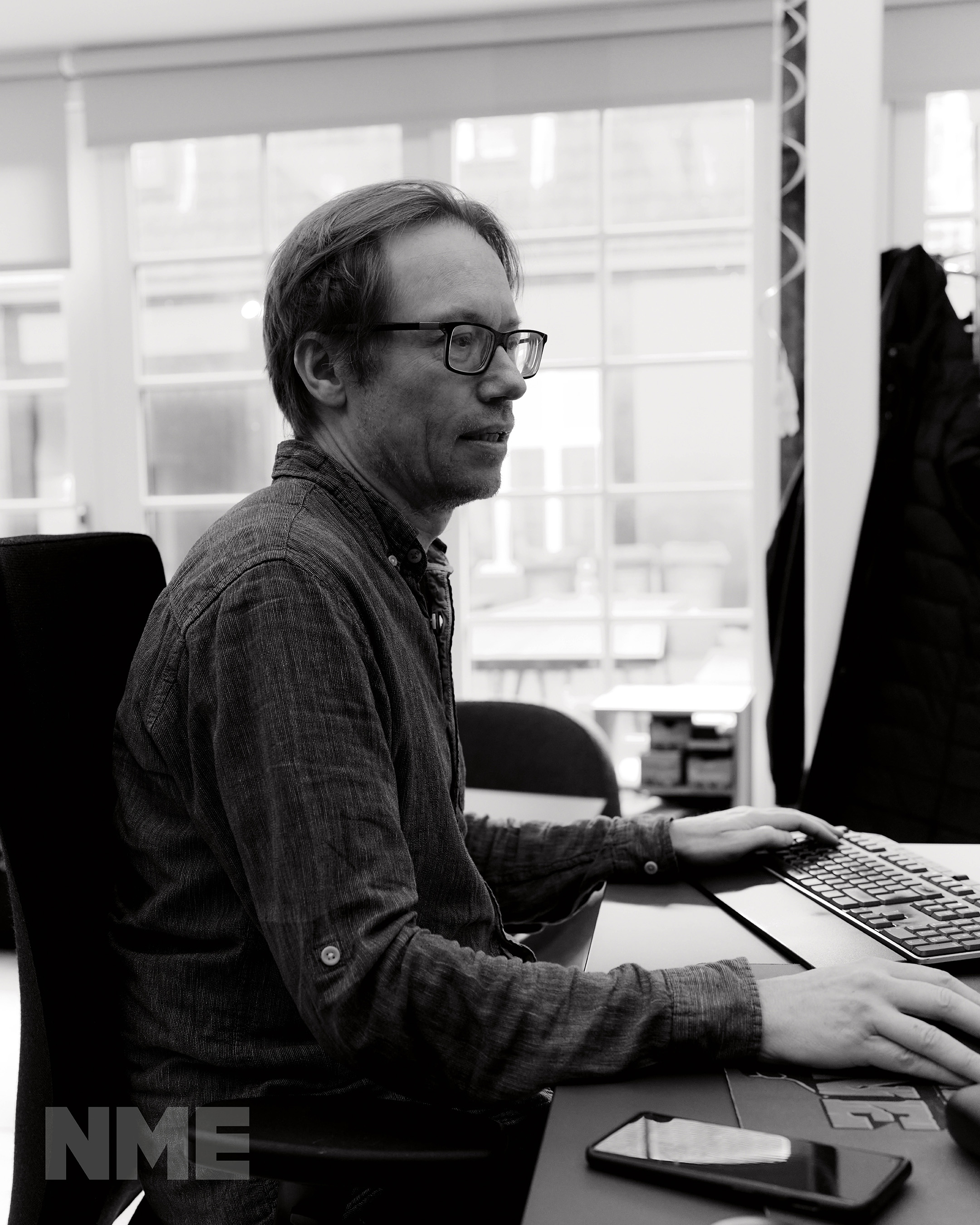 Black and white photo of Søren Lundgaard at his desk in the Ghost Ship Games office, photo by Tobias Hoffmann