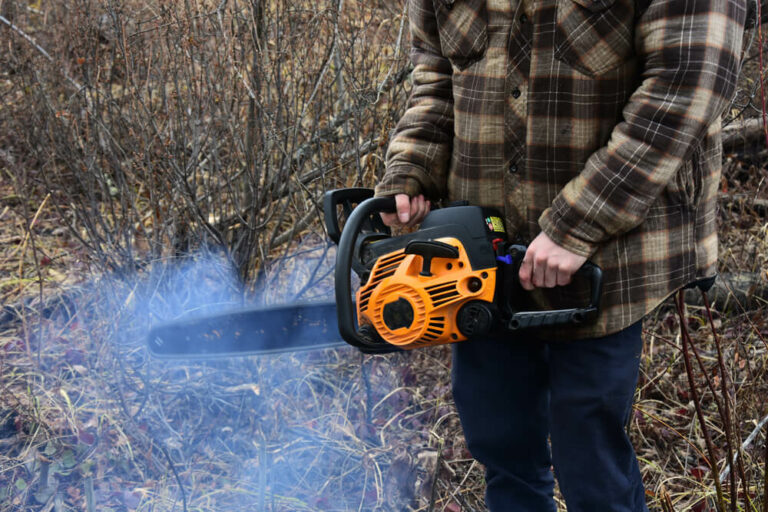 holding an old smoking chain saw