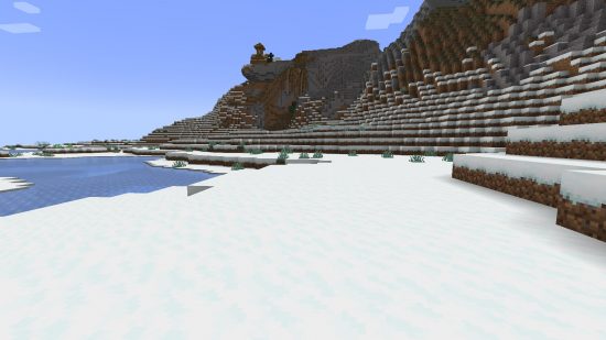 Minecraft biomes - a snowy tundra region with hills and a frozen lake.