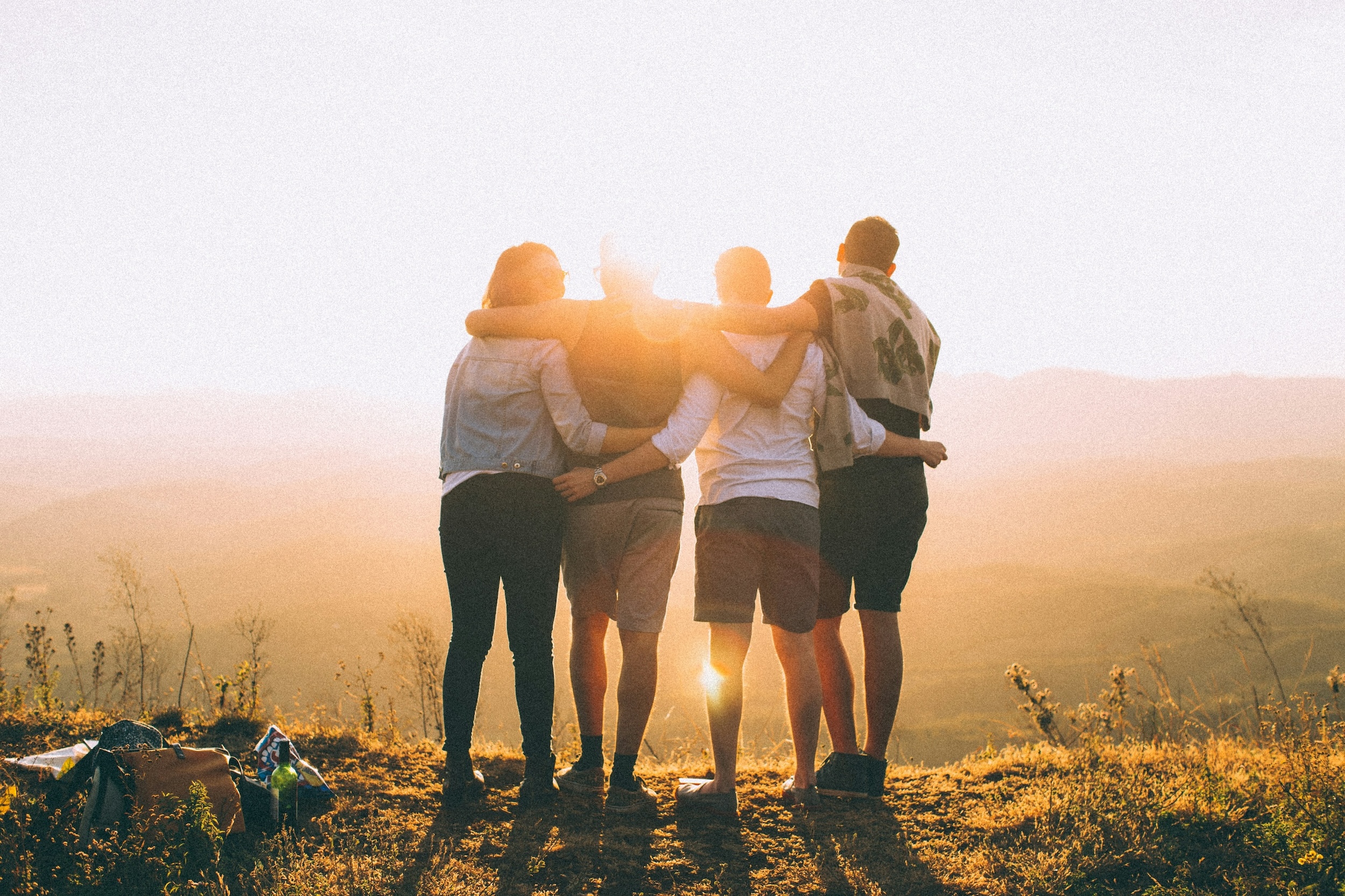 Eine Gruppe junger Menschen vor dem Sonnenuntergang.