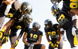 Football team huddled during time out while playing game