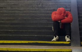 This is a photo of a teen sitting alone on a set of stairs.