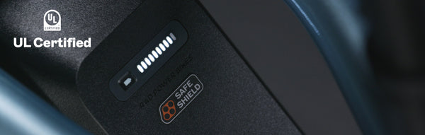 A close-up of a Safe Shield Battery on a blue ebike. A UL Certified watermark is in the upper left corner.