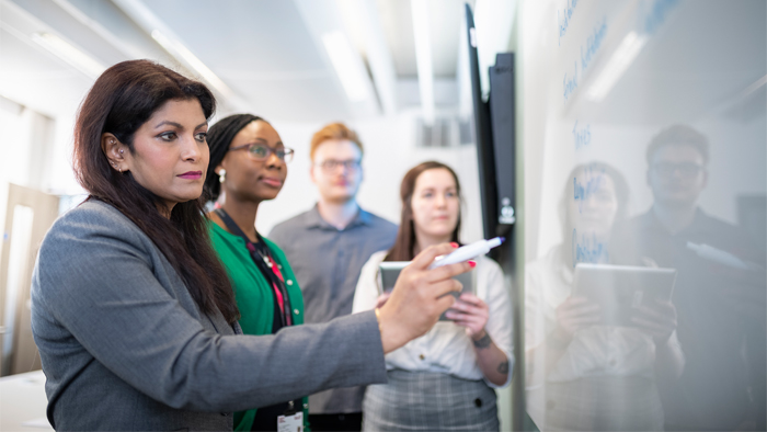 Group of people looking at a whiteboard