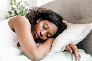 Woman of color sleeping in bed