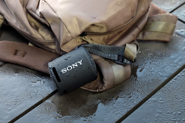 Image of a Portable Wireless Speaker under a stream of water showcasing water resistance.