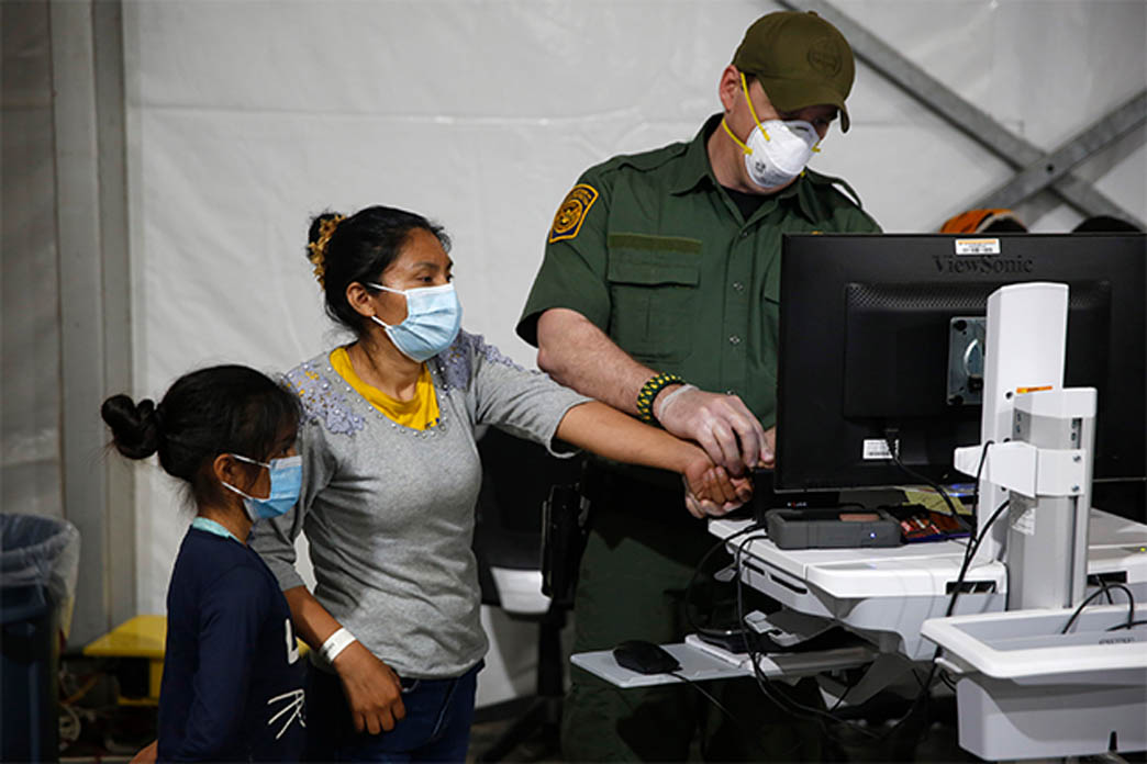 Mother and child undergo processing by immigration officer