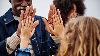 Two people clapping their hands together.