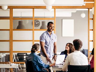 Smiling man talking to colleagues in a modern office