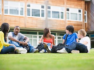 Schüler sitzen im Kreis auf einer Wiese