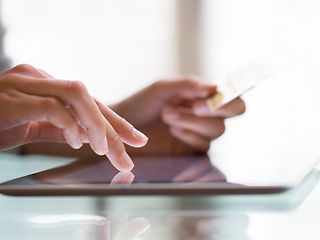 Two fingers touching a tablet