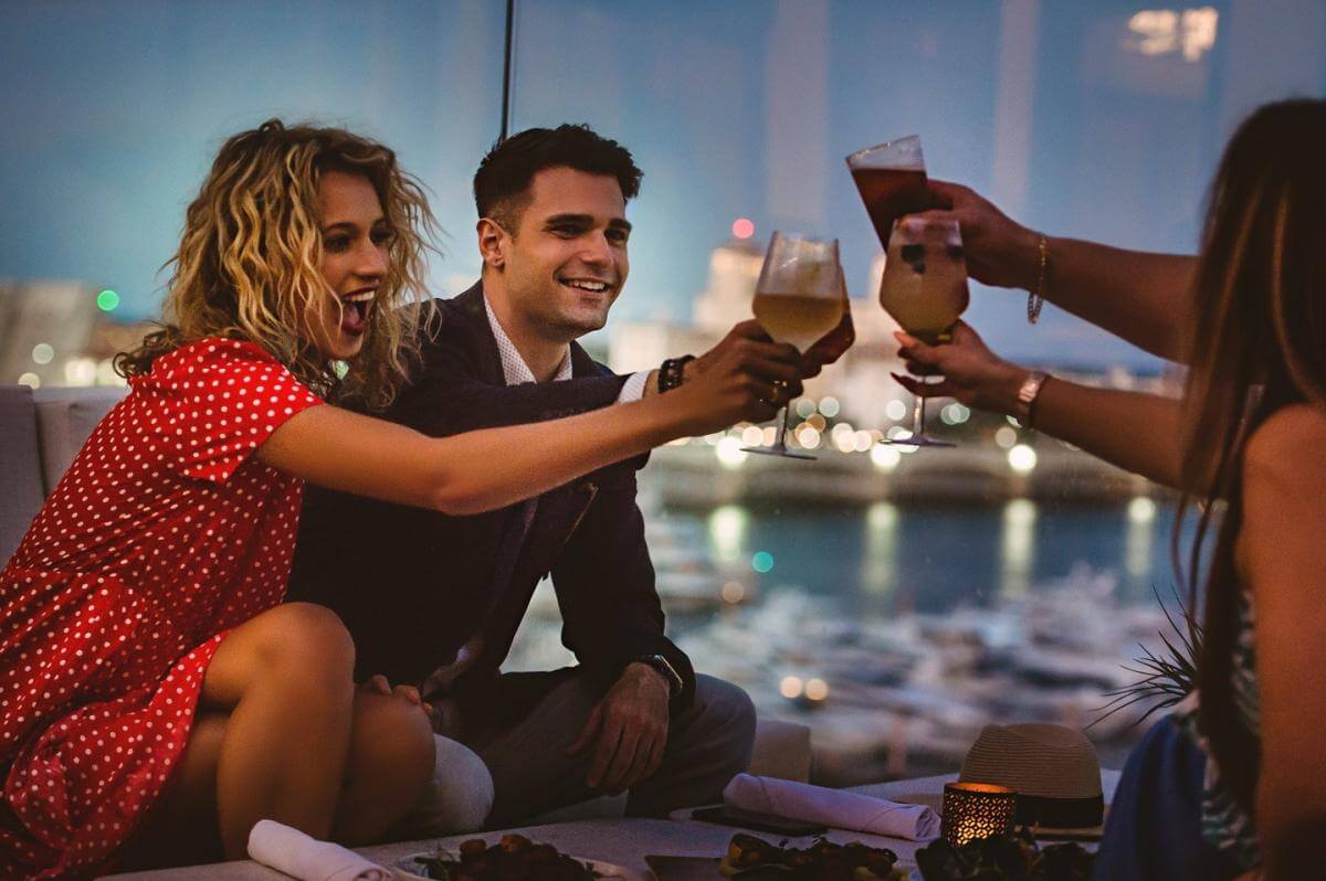 Three people drinking wine on the rooftop Spruzzo