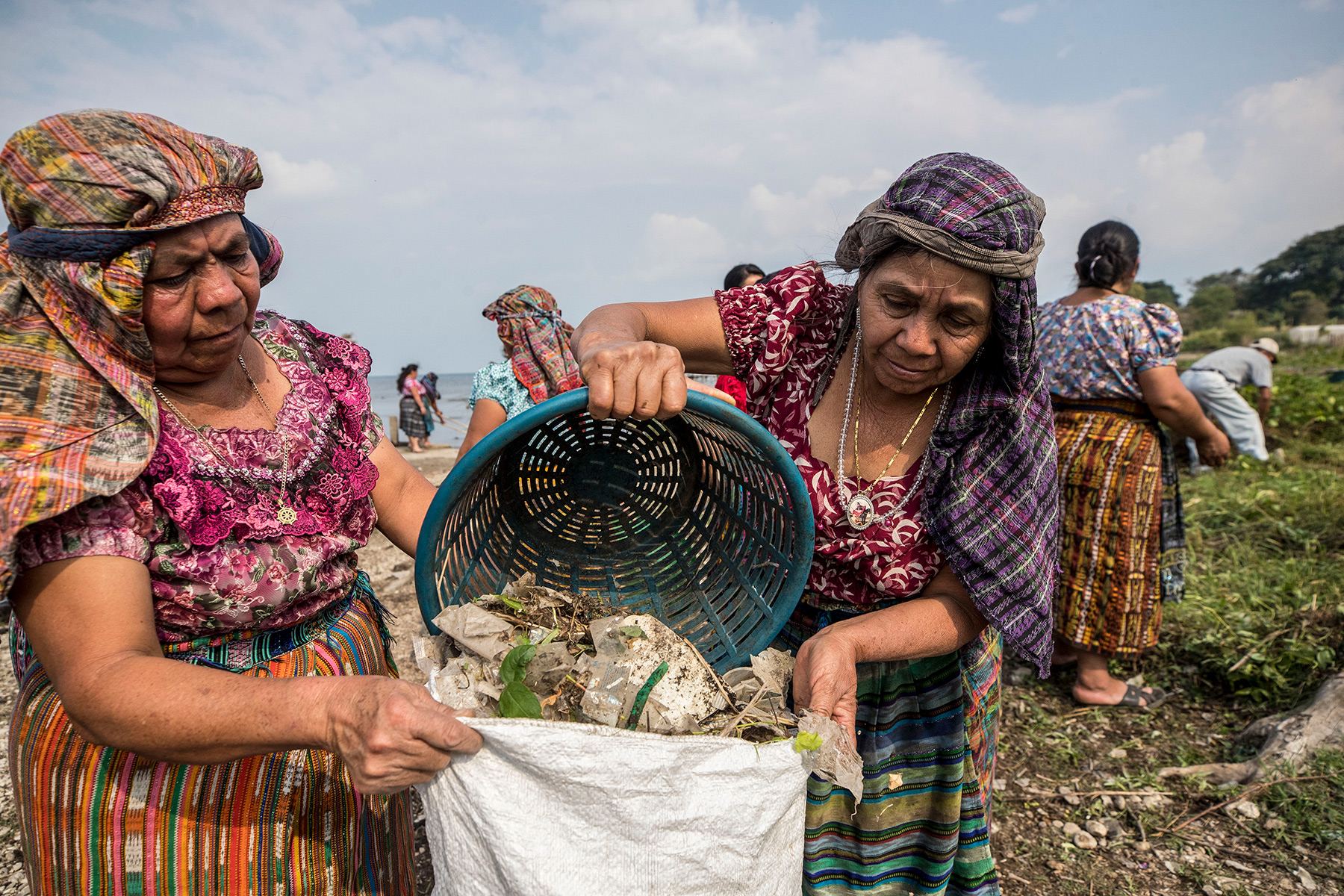 Two women putting plastic in a bag