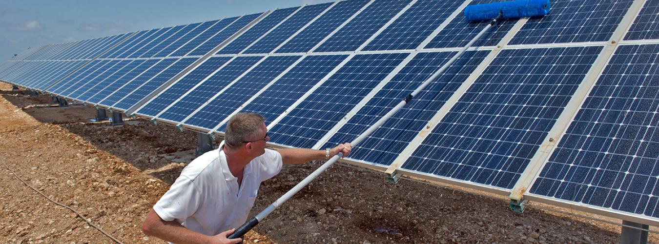 Un hombre limpiando paneles solares en un día soleado en las instalaciones de la ONU en Nqoura, Líbano.