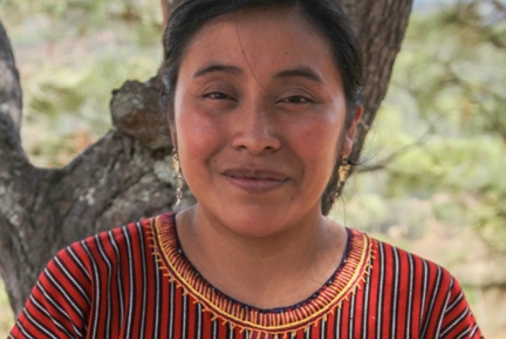 young girl smiling working in front of a tree