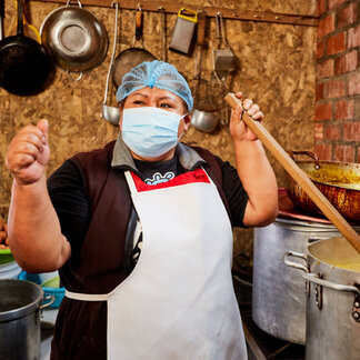 a woman is cooking food in a big pot