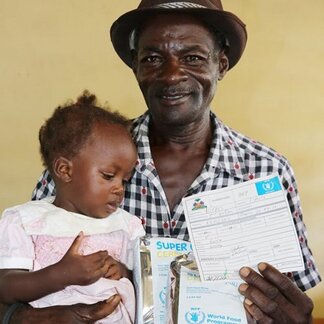 Father receiving fortified and nutrient-rich food item from WFP for his daughter