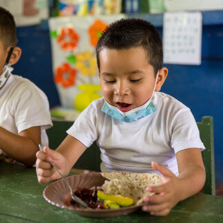 a school boy is eating his meal