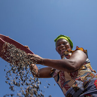 a woman is smiling and pouring grains