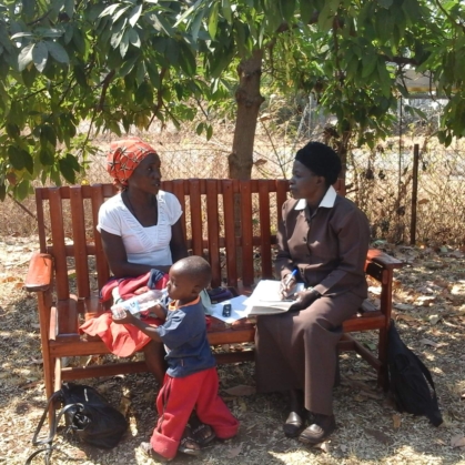 Two Black women on a bench talking